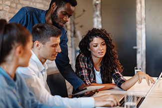 Business professionals reviewing work at computer